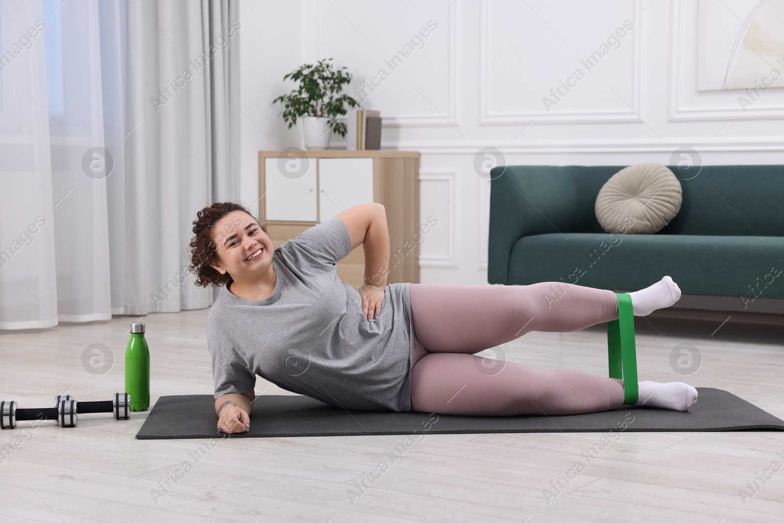 Photo of Woman training with resistance band at home