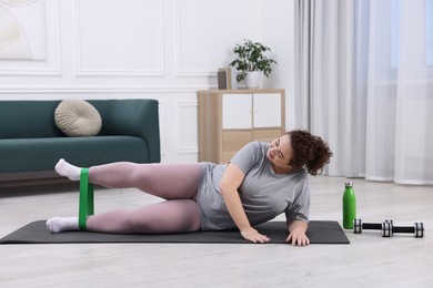 Photo of Woman training with resistance band at home