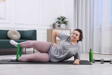 Photo of Woman training with resistance band at home