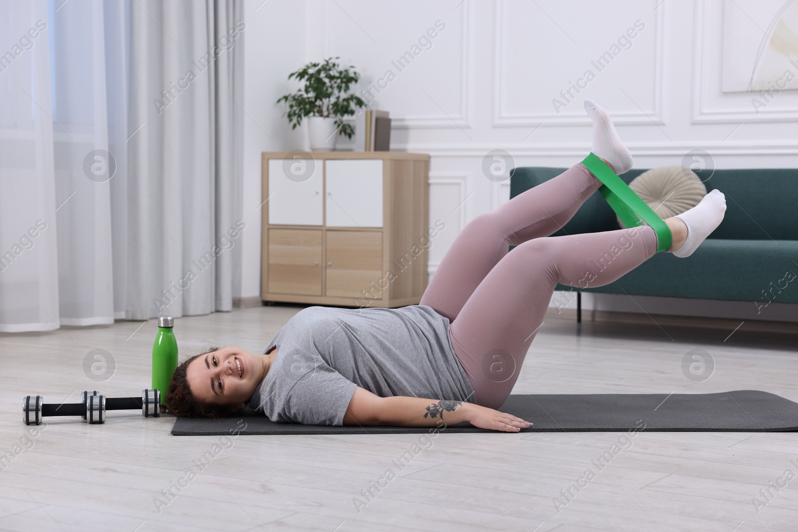 Photo of Woman training with resistance band at home