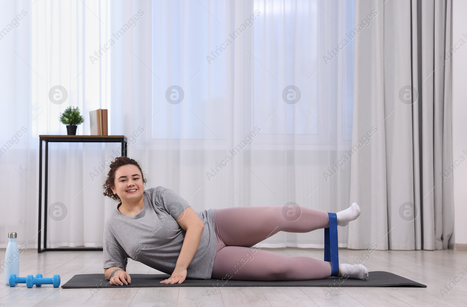 Photo of Woman training with resistance band at home