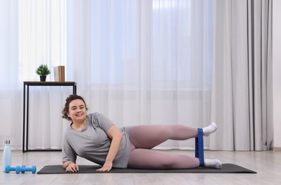 Photo of Woman training with resistance band at home