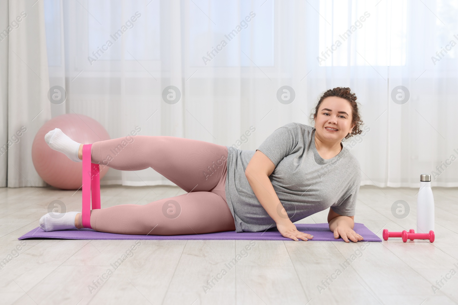 Photo of Woman training with resistance band at home