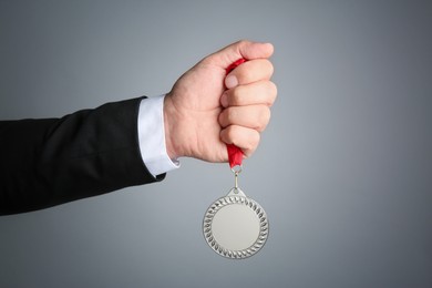 Photo of Man with silver medal on grey background, closeup