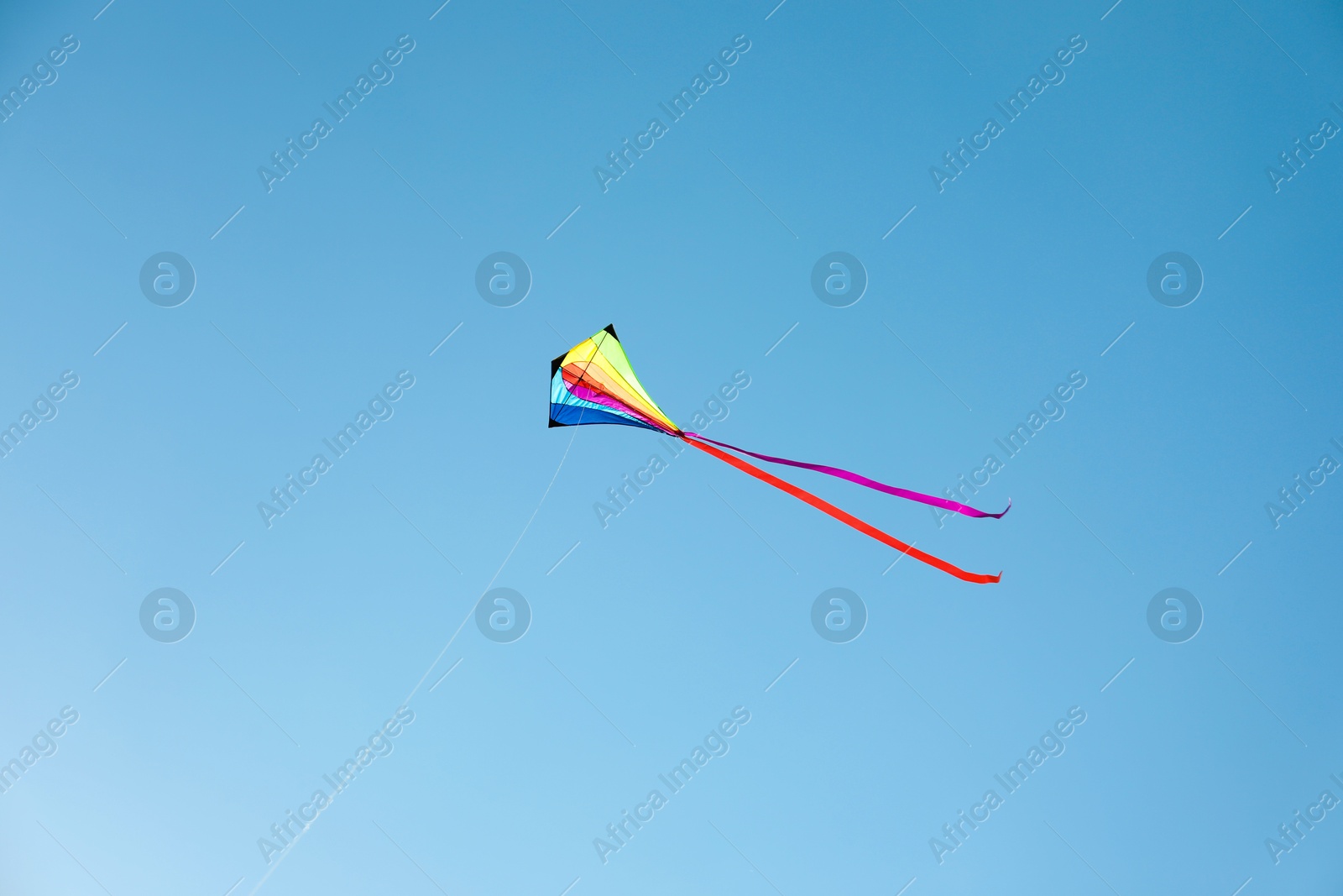 One colorful kite flying in blue sky Photo of One colorful kite flying in blue sky