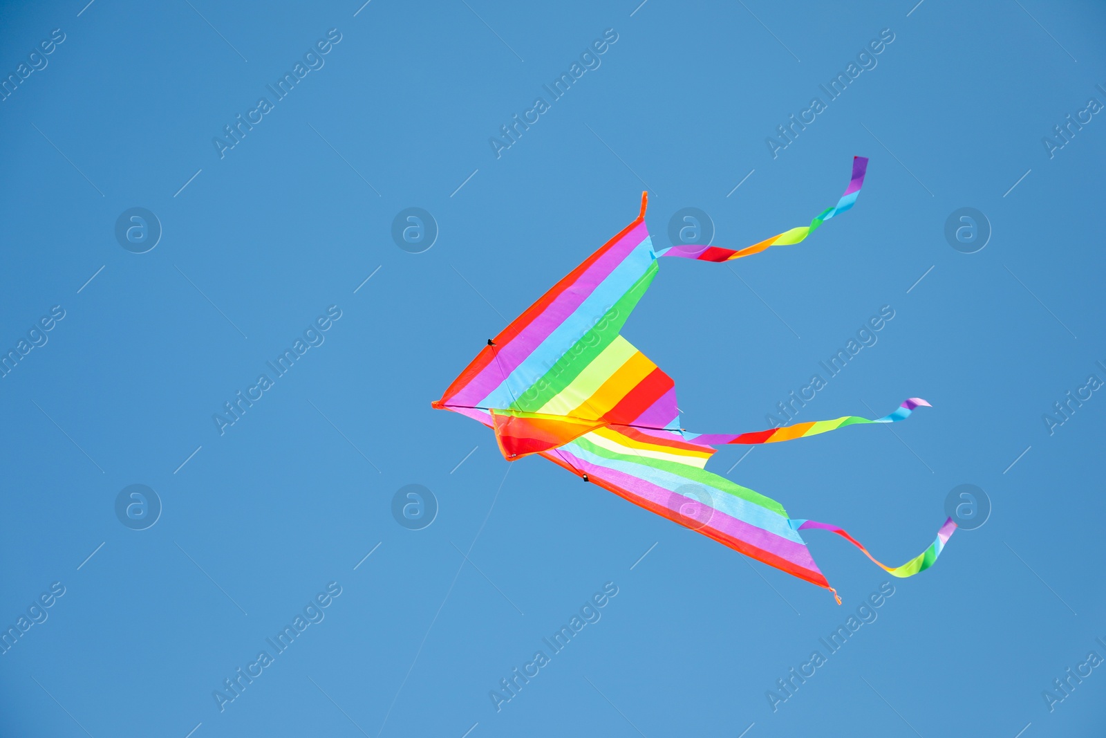 One colorful kite flying in blue sky Photo of One colorful kite flying in blue sky
