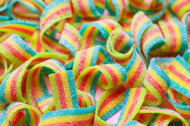 Photo of Tasty rainbow sour belts as background, closeup