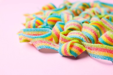 Photo of Tasty rainbow sour belts on pink background, closeup