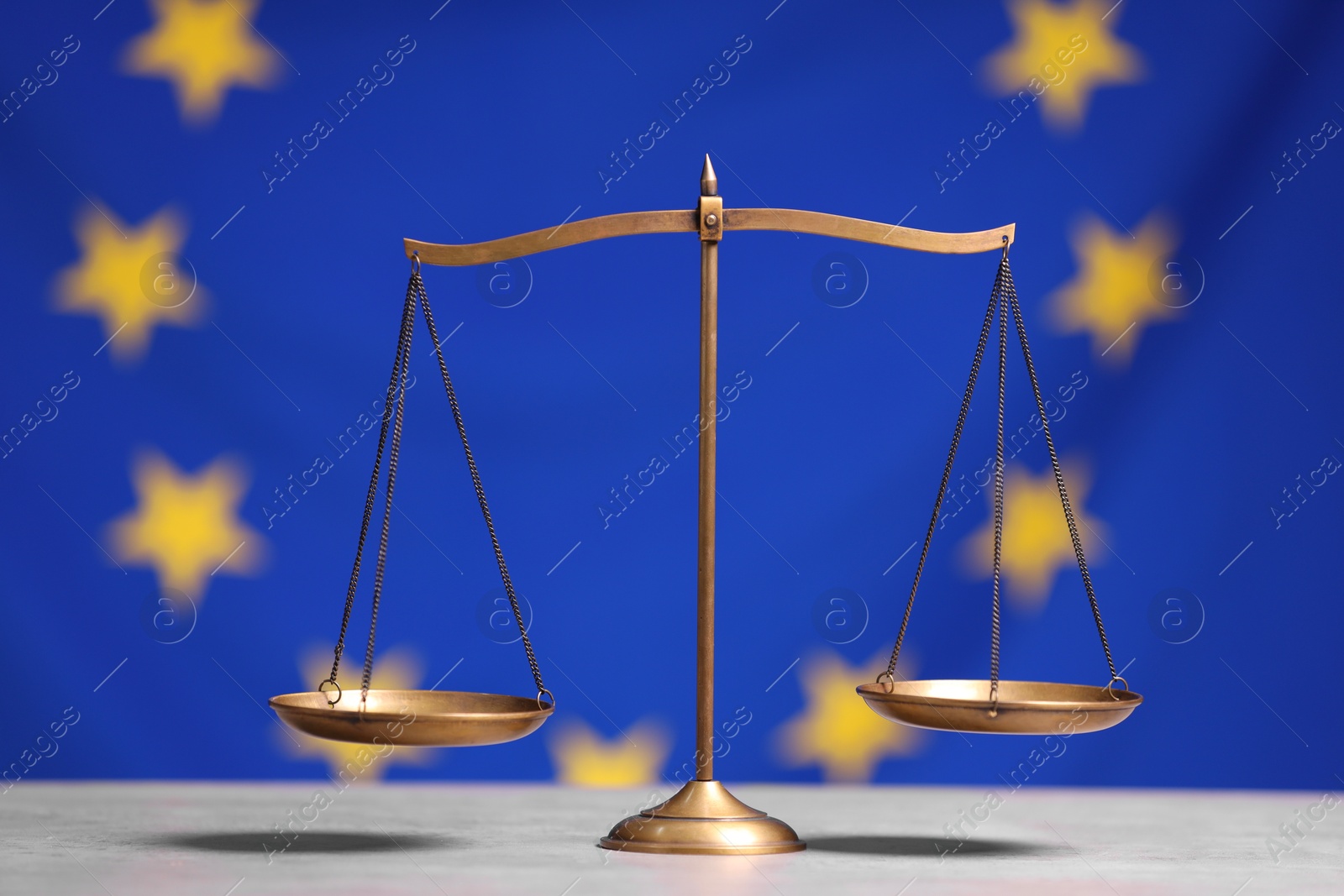 Photo of Scales of justice on table against European Union flag