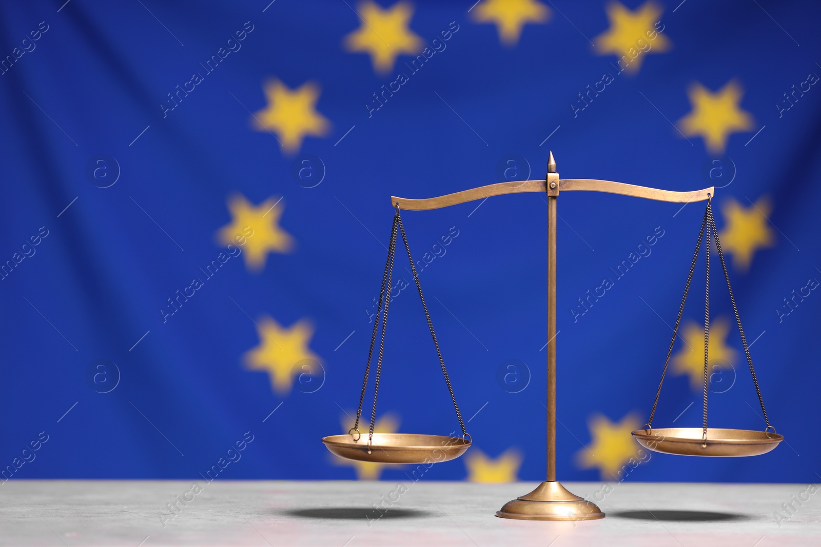 Photo of Scales of justice on table against European Union flag, space for text