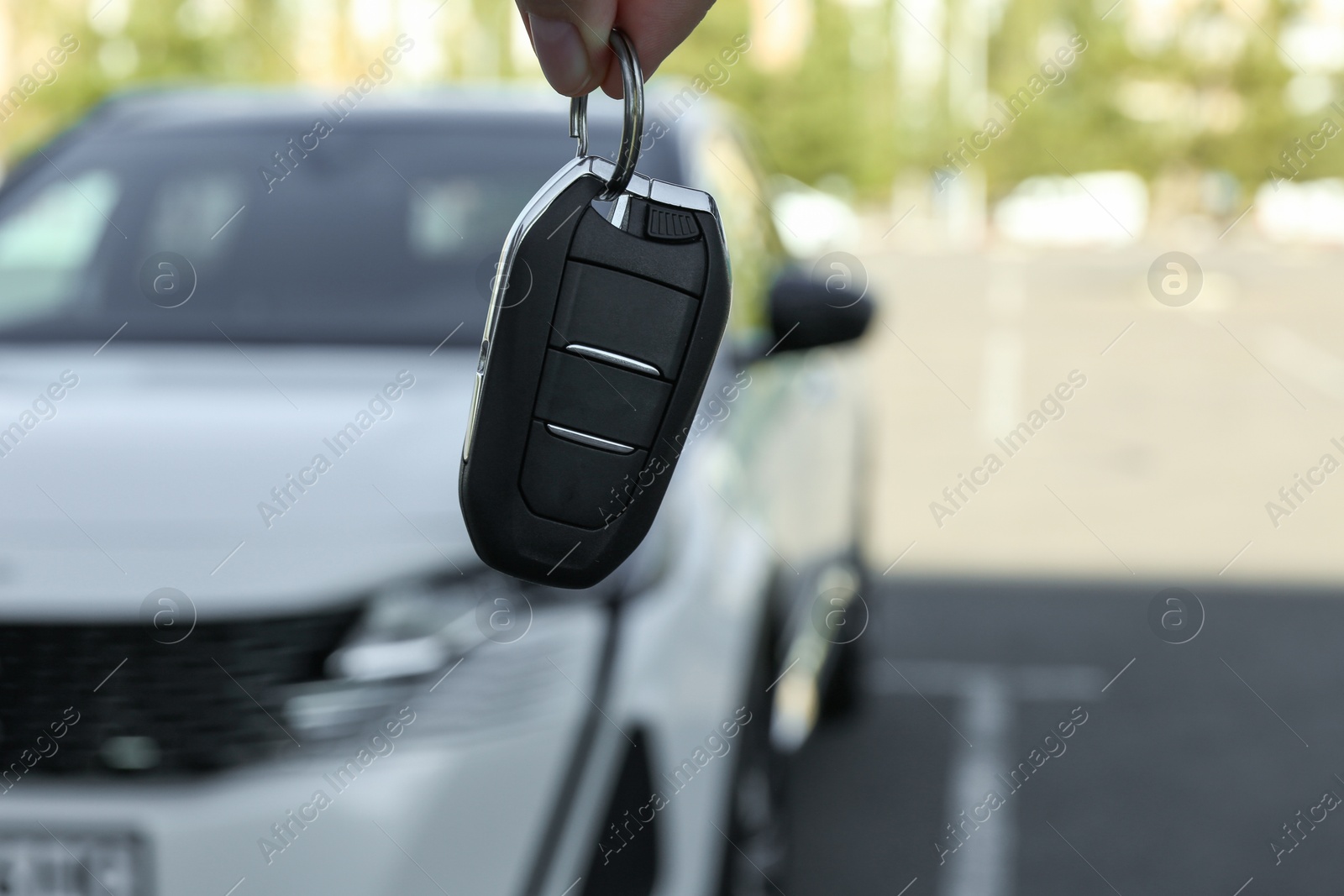 Photo of Woman holding key near car outdoors, closeup