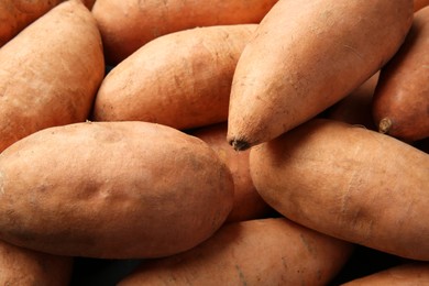 Photo of Fresh raw sweet potatoes as background, closeup