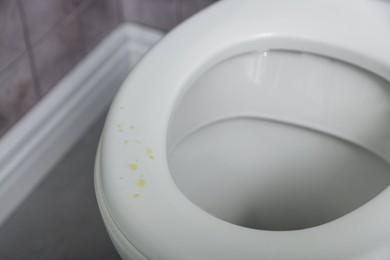 Photo of Urine drops on toilet seat in restroom, closeup