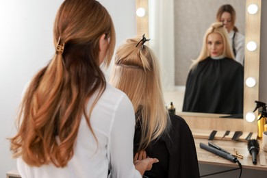 Photo of Hair cutting. Professional hairdresser working with client in salon