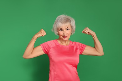 Photo of Senior woman exercising on green background. Healthy lifestyle