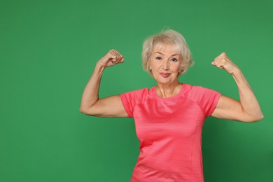 Photo of Senior woman exercising on green background. Healthy lifestyle