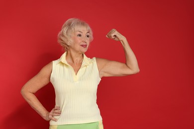 Photo of Senior woman exercising on red background, space for text