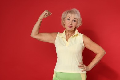 Photo of Senior woman exercising on red background. Healthy lifestyle