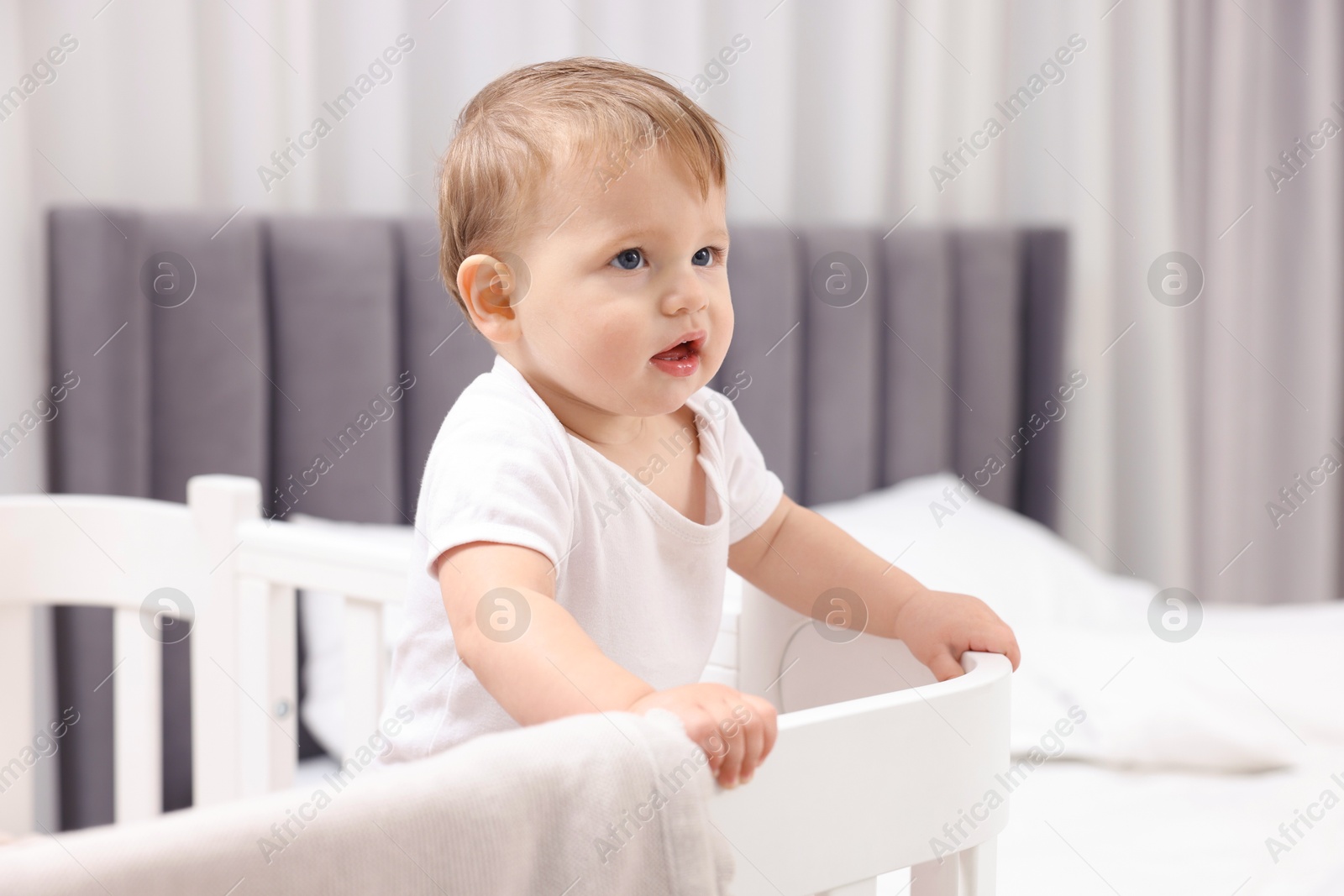 Photo of Cute little baby in crib at home