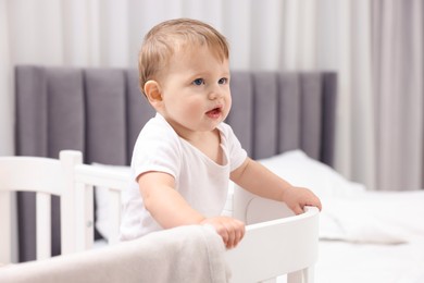 Photo of Cute little baby in crib at home