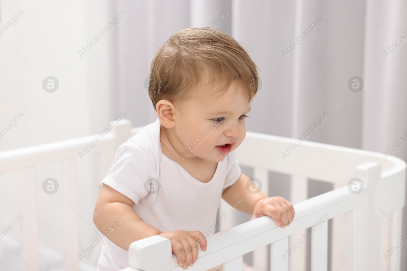 Photo of Cute little baby in crib at home