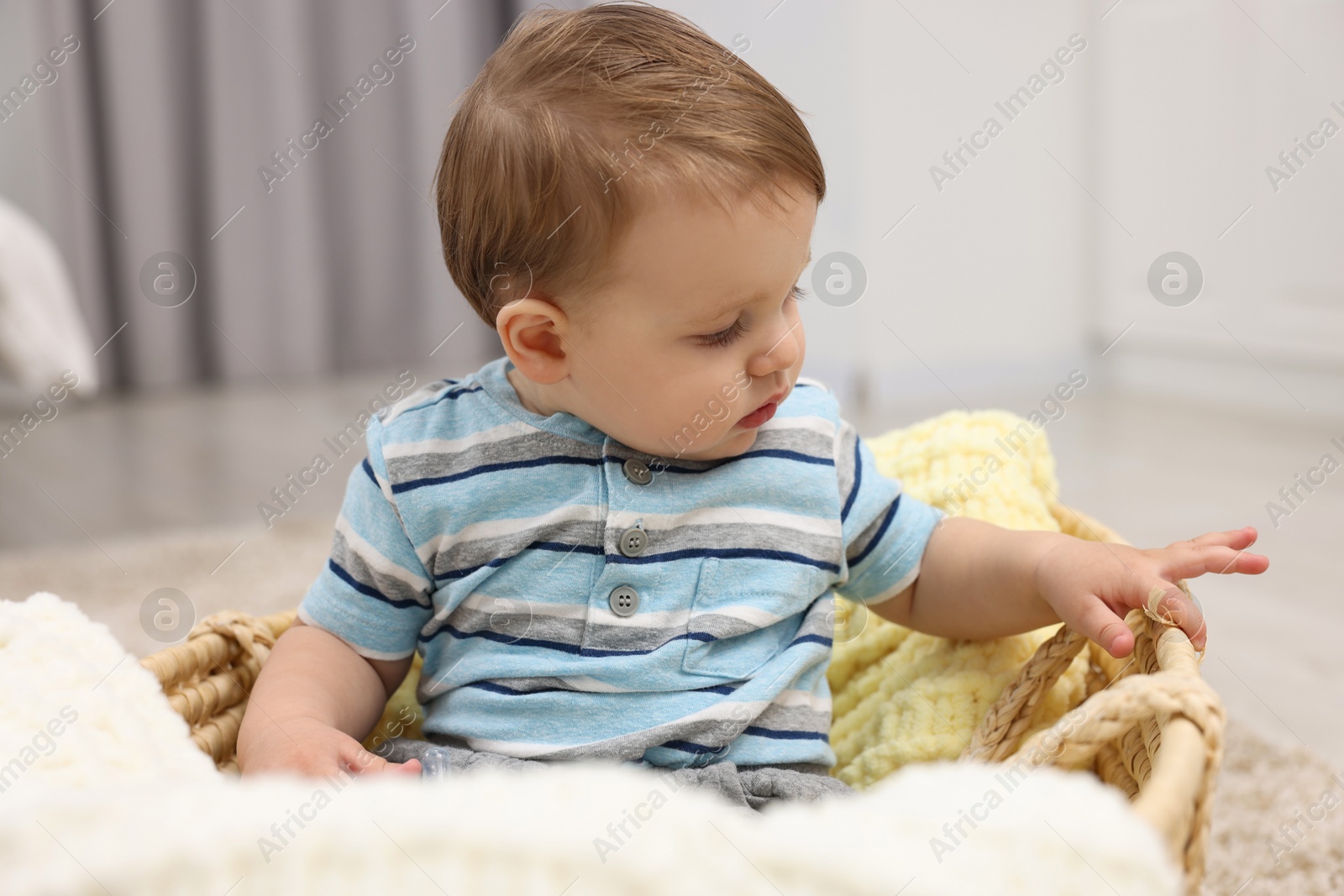 Photo of Cute baby boy in basket at home