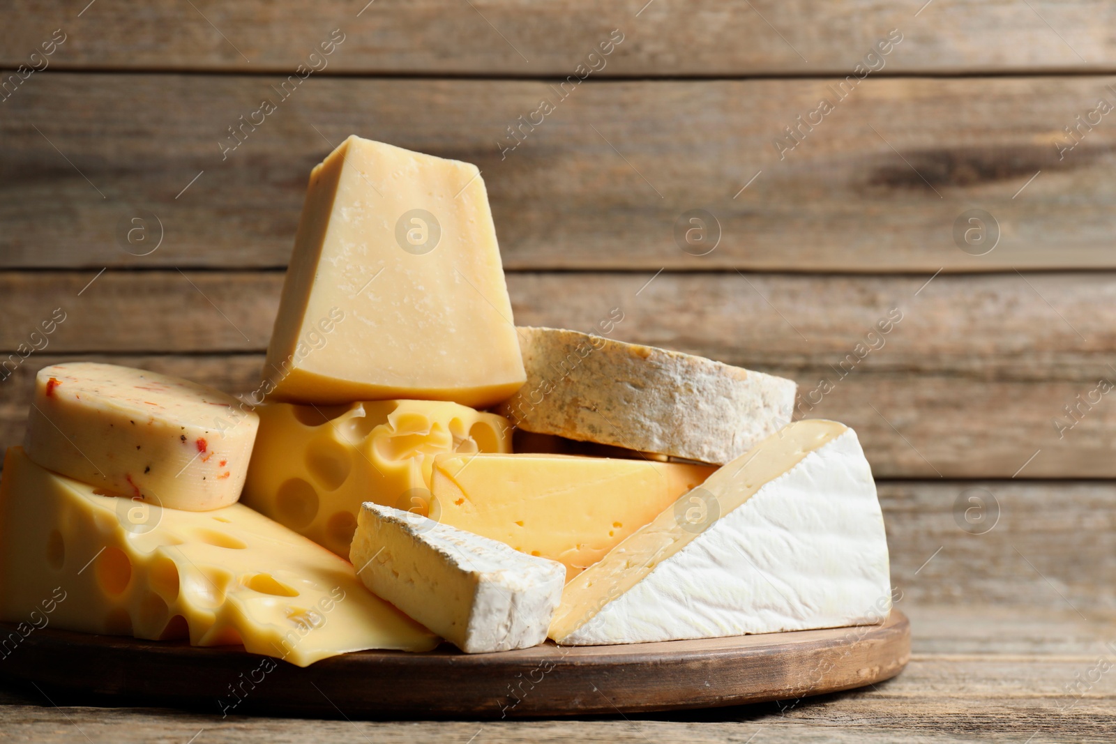 Photo of Different types of cheese on wooden table