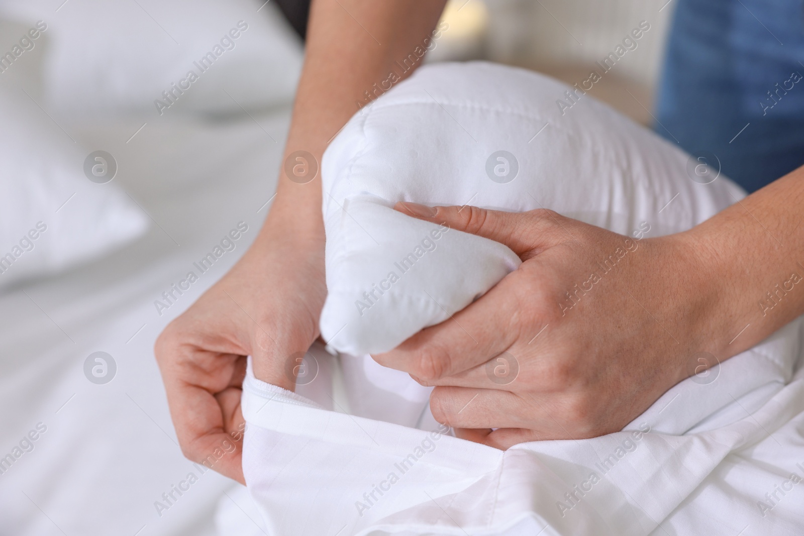 Photo of Woman changing clean bed linens at home, closeup