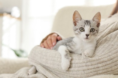 Photo of Woman with cute kitten at home, closeup