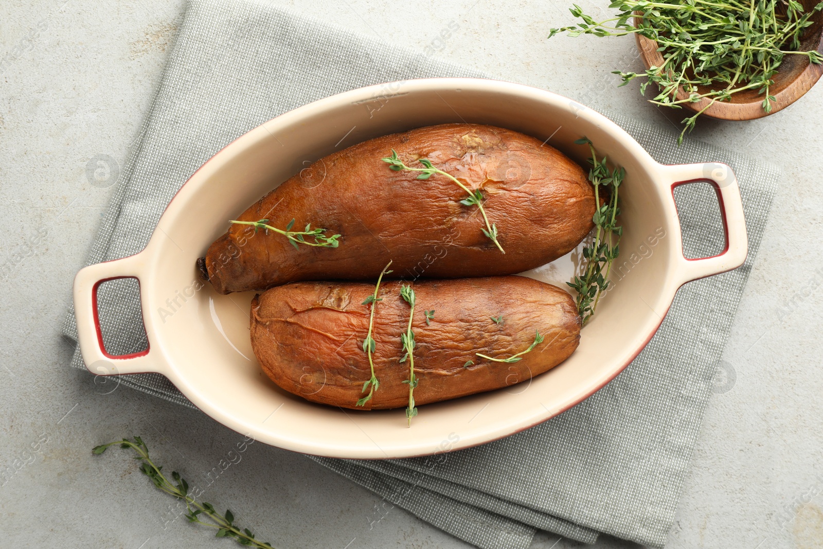 Photo of Tasty cooked sweet potatoes served with thyme on light grey table, flat lay