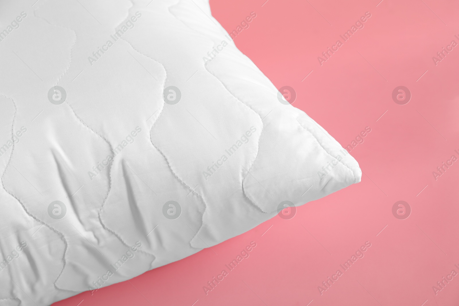 Photo of Pillow with clean pillowcase on pink background, closeup