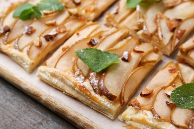 Photo of Tasty puff pastry pie with pears and mint on table, closeup