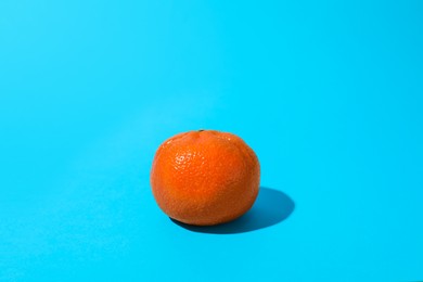 Photo of Fresh ripe tangerine on light blue background