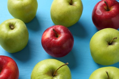 Photo of Fresh red and green apples on light blue wooden table