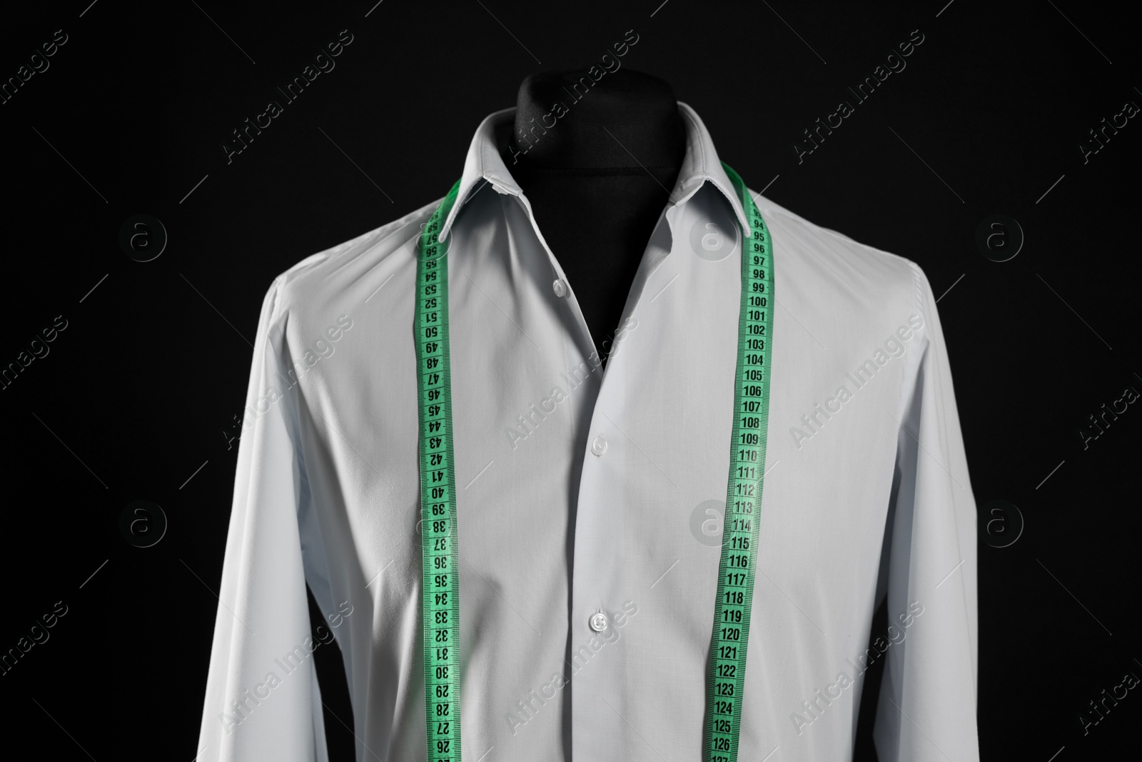 Photo of Male mannequin with shirt and measuring tape on black background