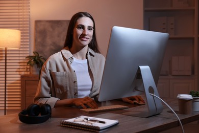 Photo of Programmer working on computer at wooden desk indoors