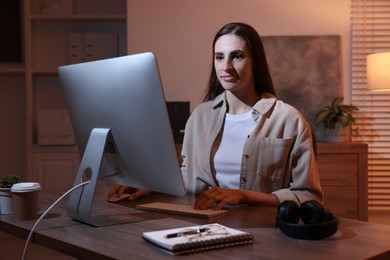 Photo of Programmer working on computer at wooden desk indoors