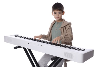 Photo of Cute boy playing synthesizer on white background