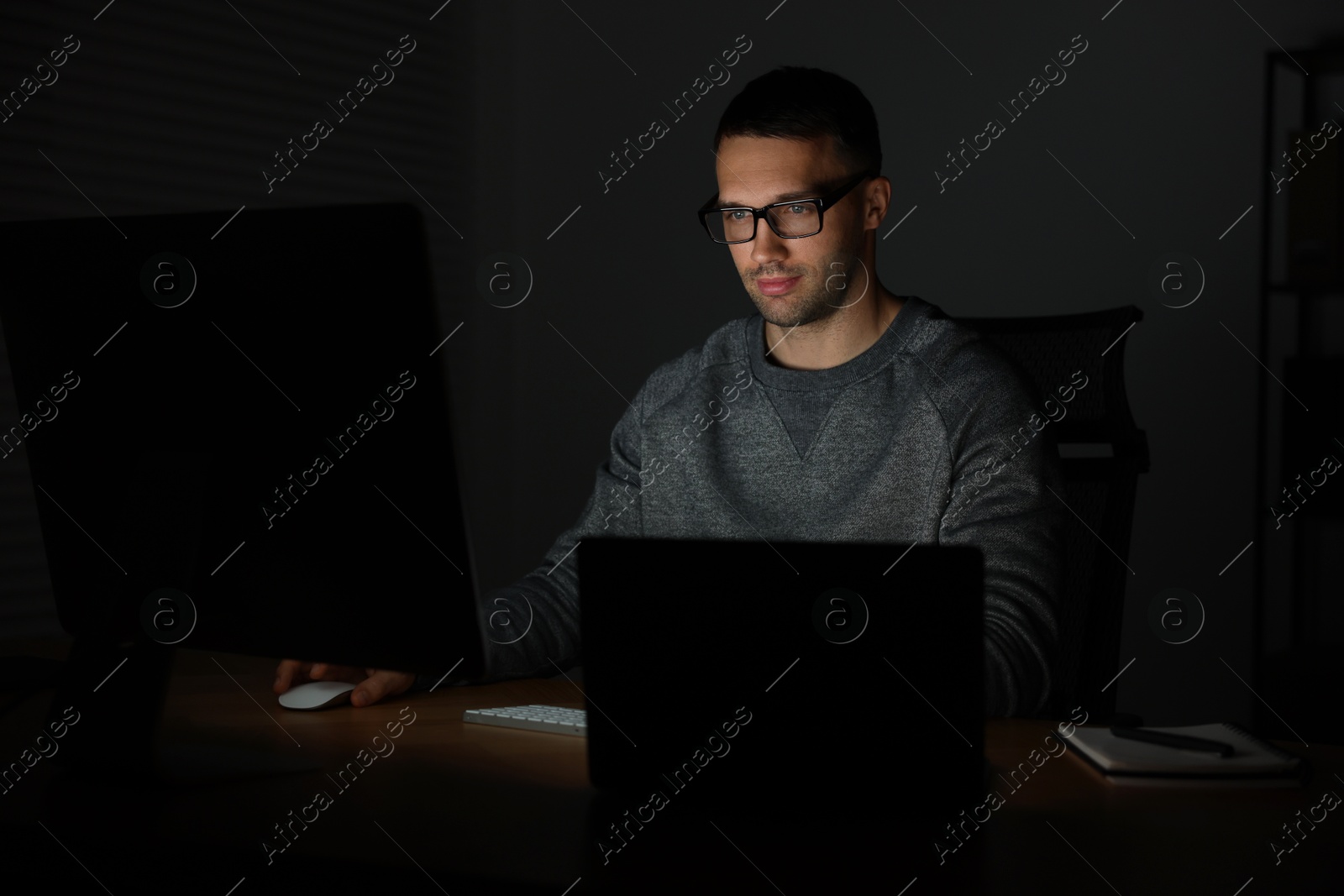 Photo of Programmer working on computer indoors at night