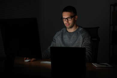 Photo of Programmer working on computer indoors at night