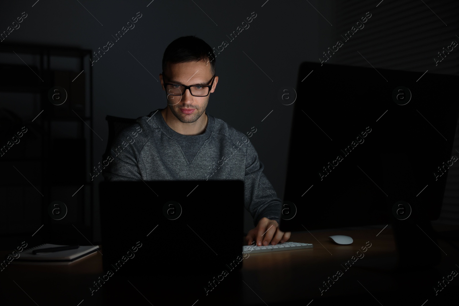 Photo of Programmer working on laptop indoors at night