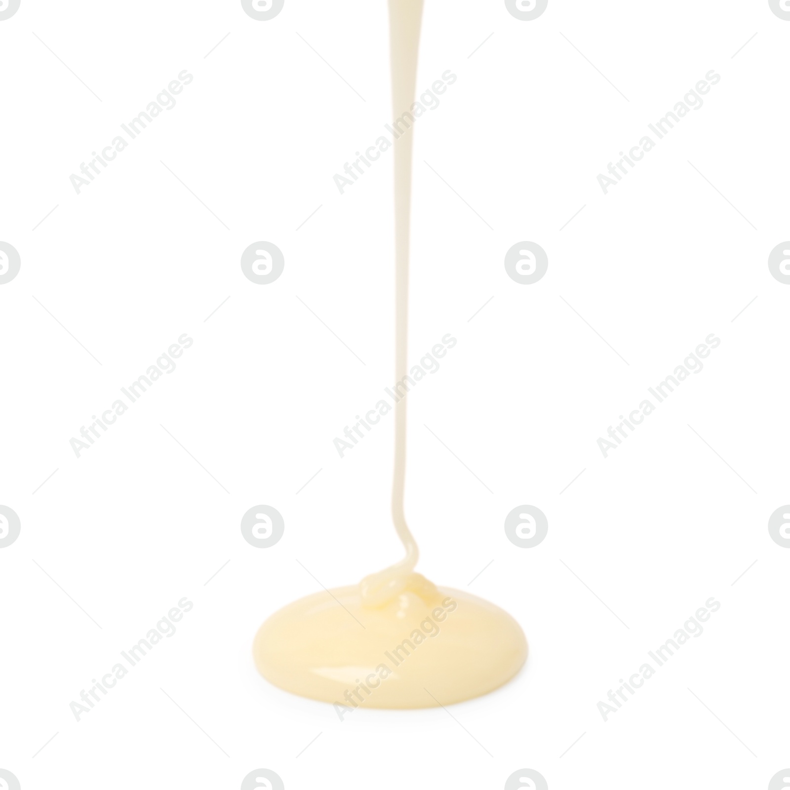 Photo of Pouring delicious condensed milk isolated on white