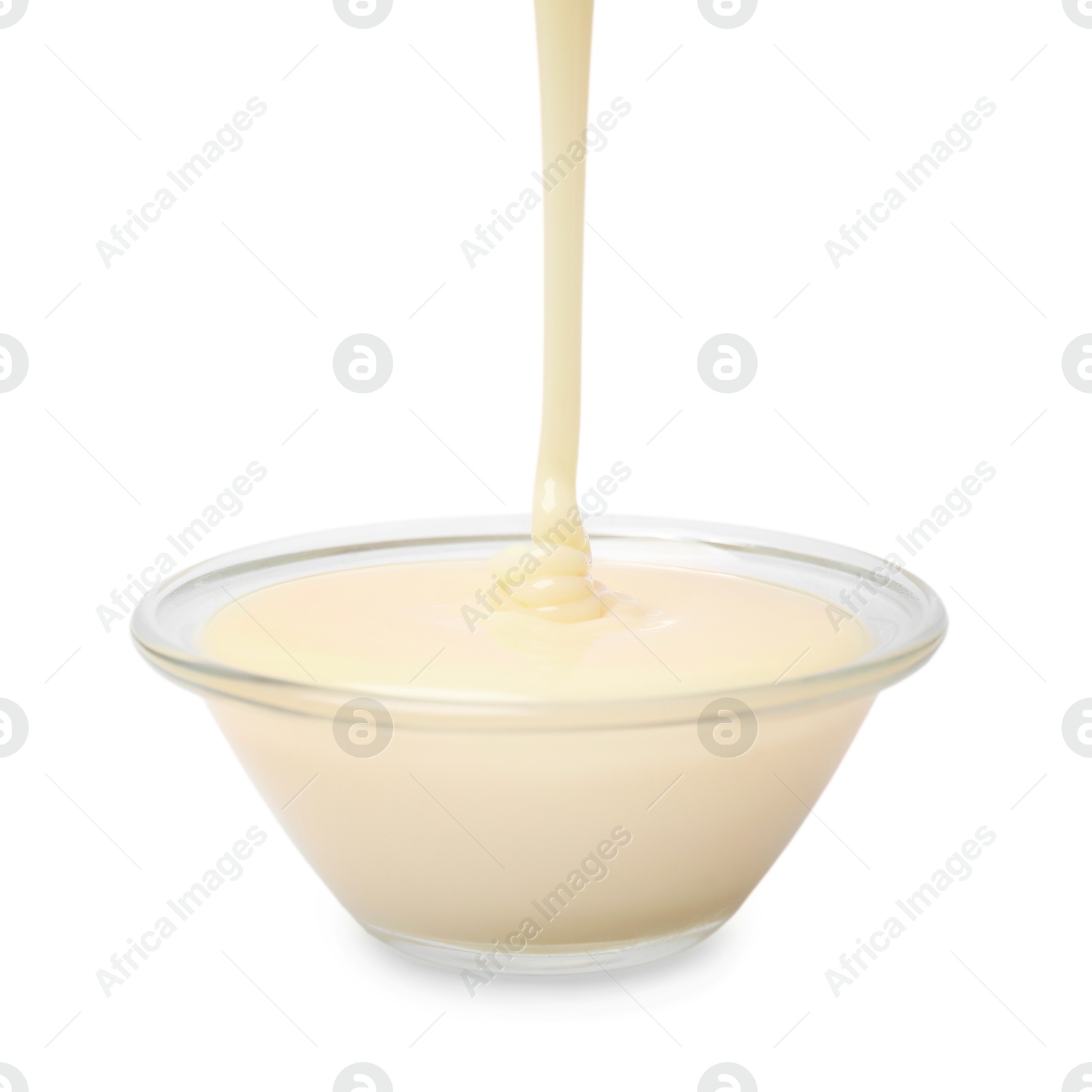 Photo of Pouring condensed milk into bowl isolated on white