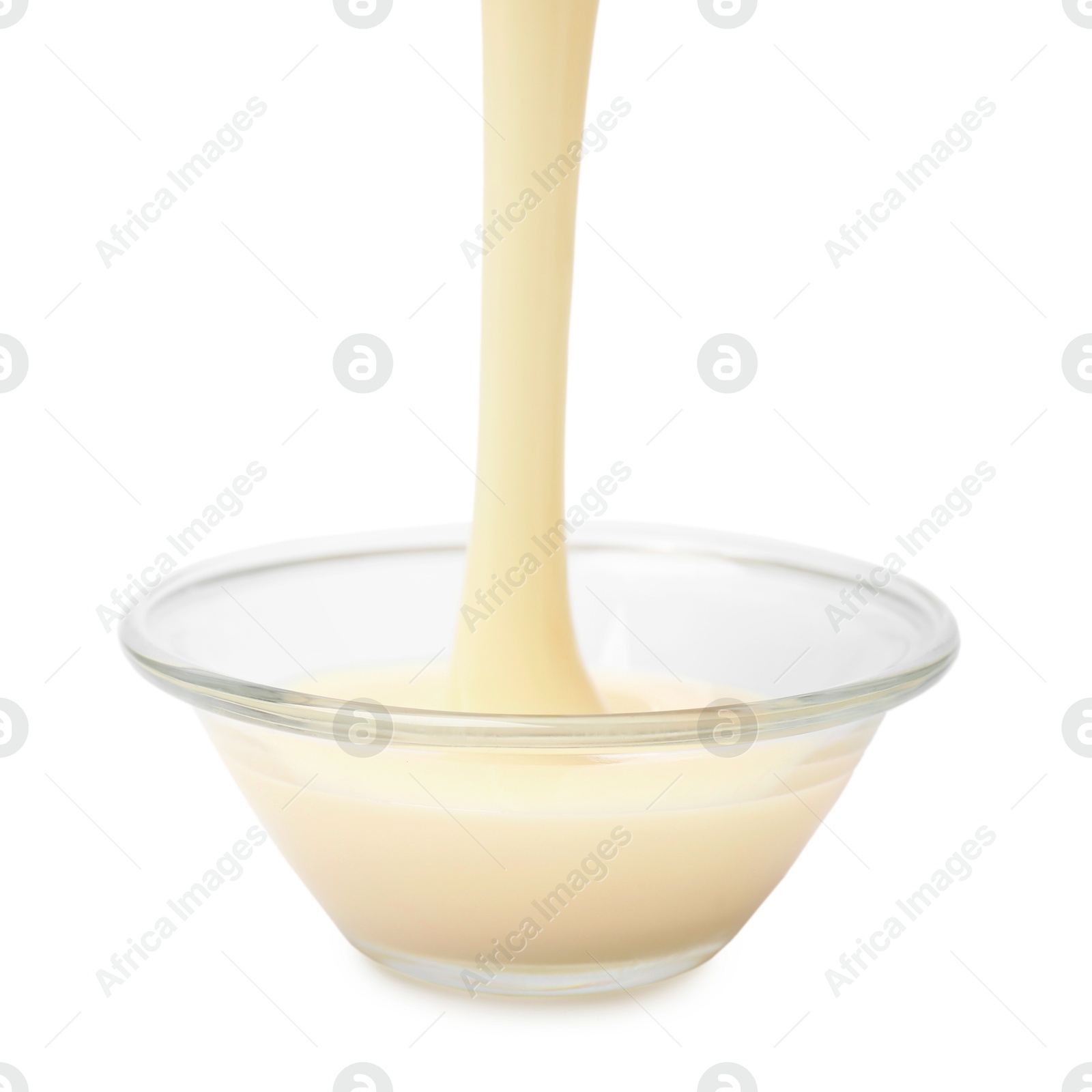 Photo of Pouring condensed milk into bowl isolated on white