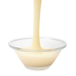 Photo of Pouring condensed milk into bowl isolated on white