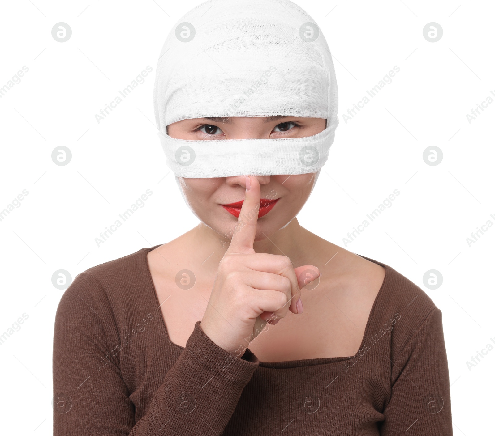 Photo of Woman with nose wrapped in medical bandage after plastic surgery operation making silent gesture on white background