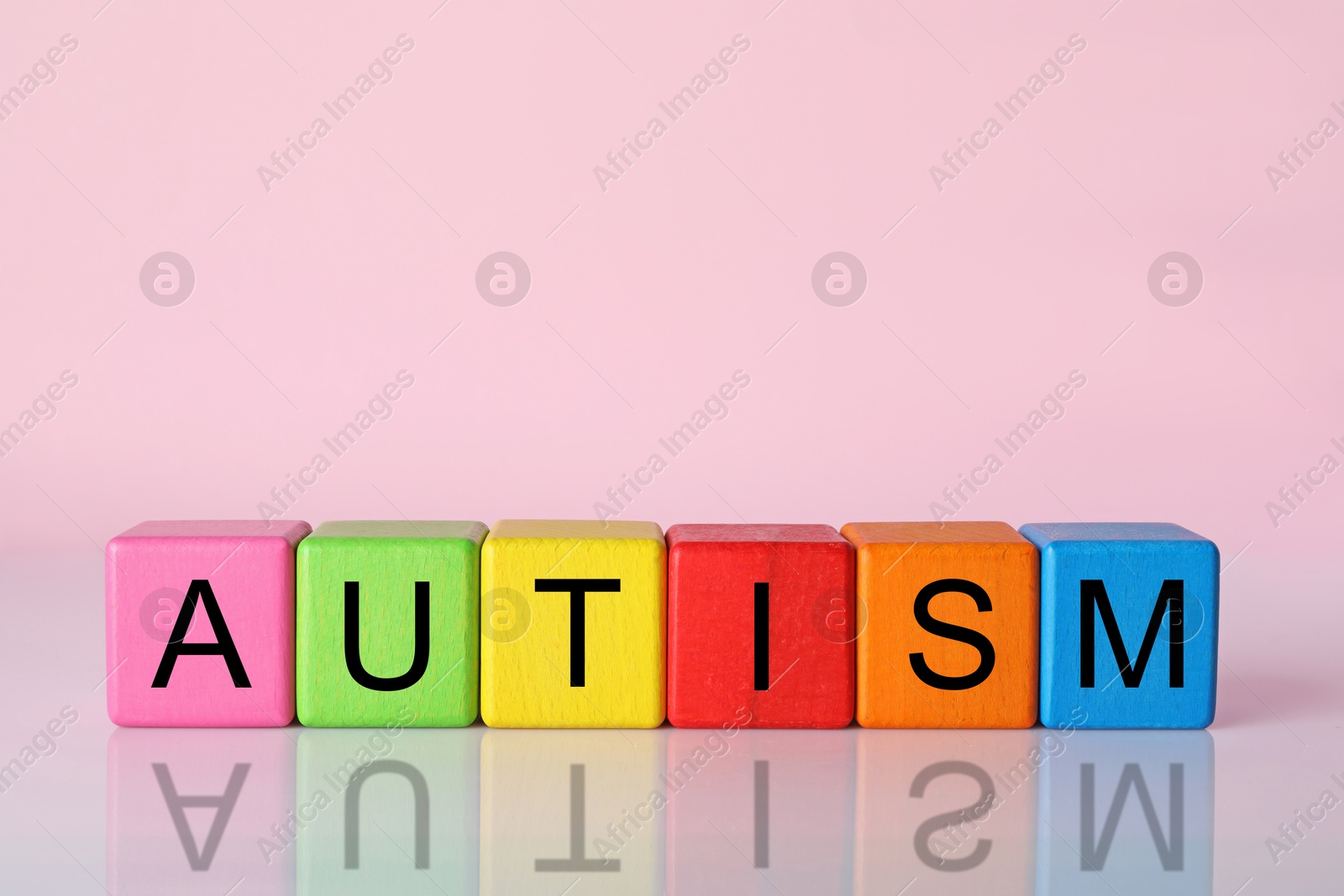 Photo of Word Autism made of colorful cubes against pink background, space for text