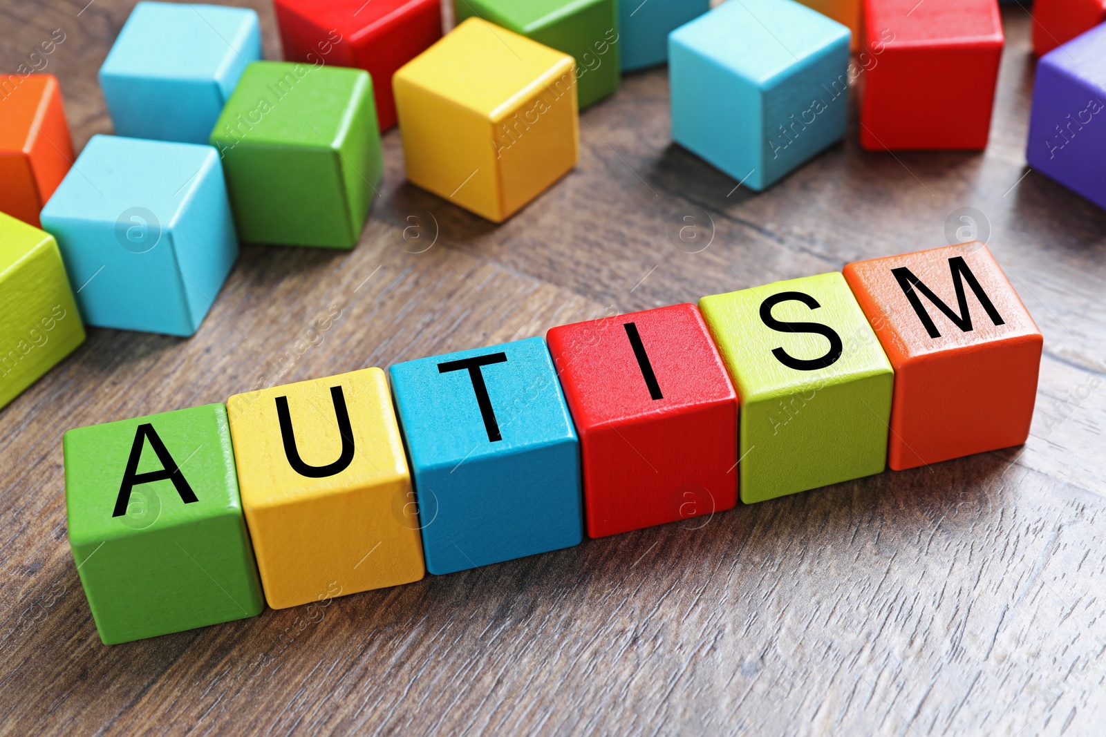 Photo of Word Autism made of colorful cubes on wooden background