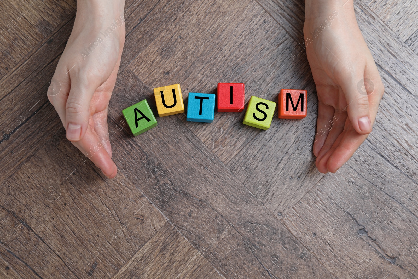 Photo of Autism concept. Woman with colorful cubes at wooden table, top view