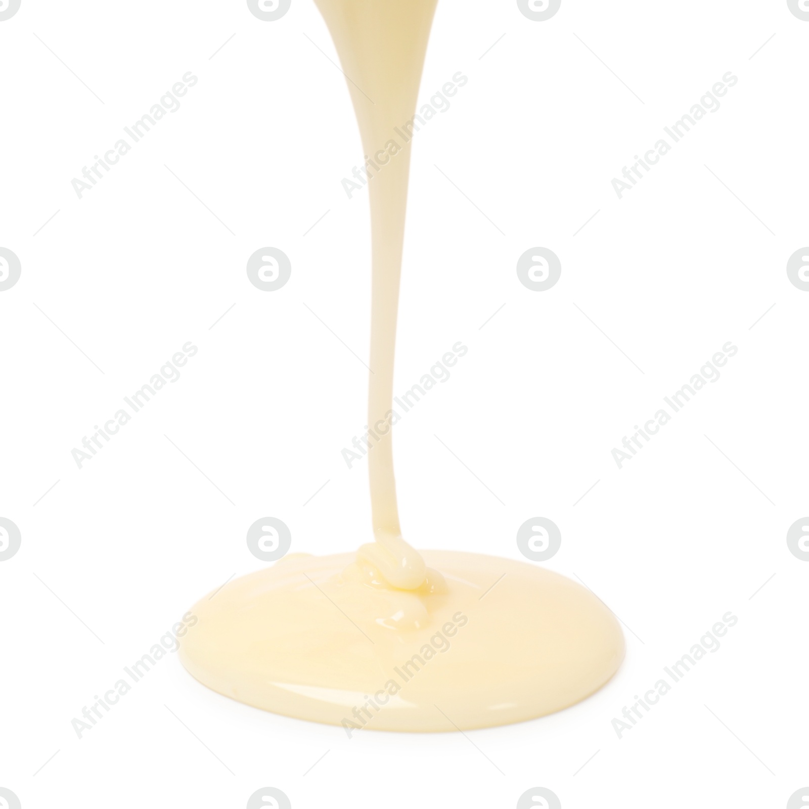 Photo of Pouring delicious condensed milk isolated on white